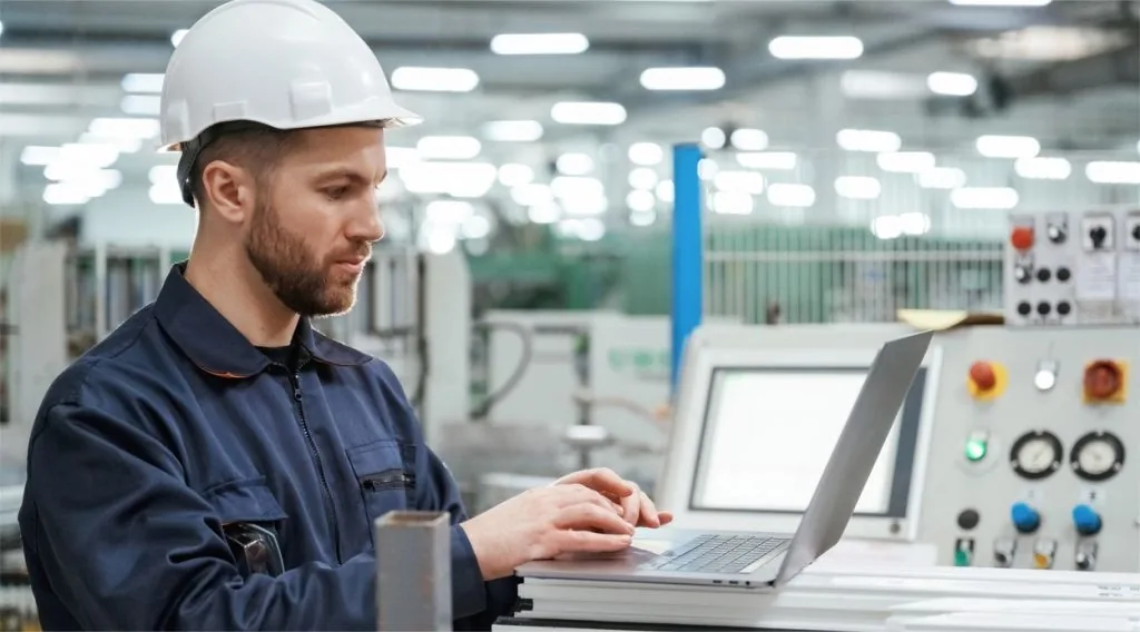 Engenheiro da Módulo em painel de controle e automação industrial durante o loop-check, com o supervisório na tela.